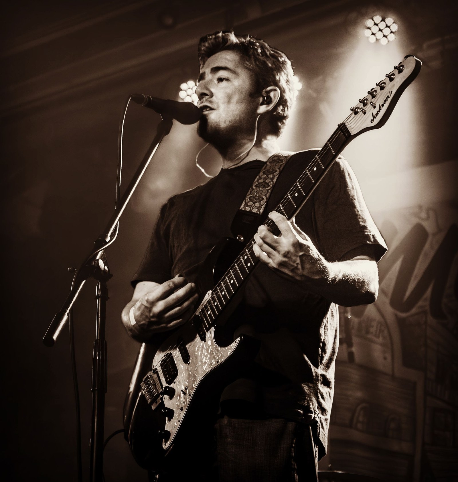 Alific playing guitar live — black and white