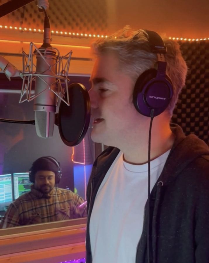 Musician at a studio microphone with headphones on