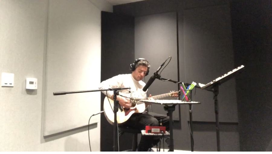 Musician tracking guitar in a studio room